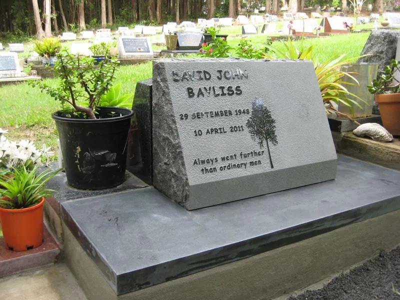 Black granite desk-style headstone with rustic top and sides on a honed black granite base at Byron Bay Cemetery