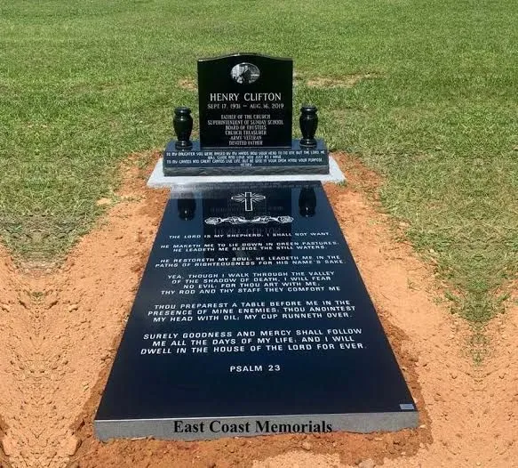 Full black granite monument with headstone, vases and inscribed ledger