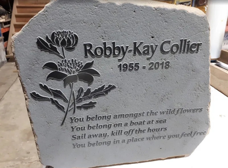 Small basalt headstone for Robby-Kay Collier with a raised inscription and waratah motif