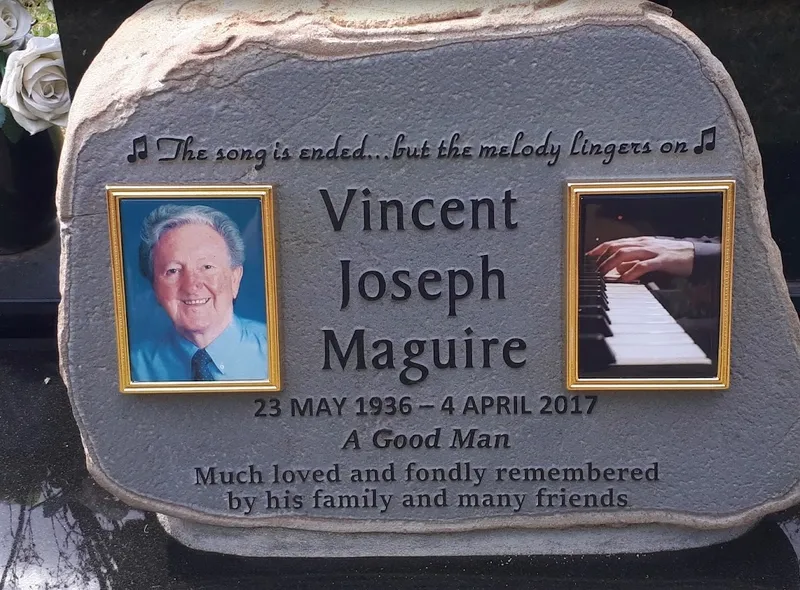 Close-up of the basalt boulder for Vincent Joseph Maguire showing colour ceramic photos and a raised inscription